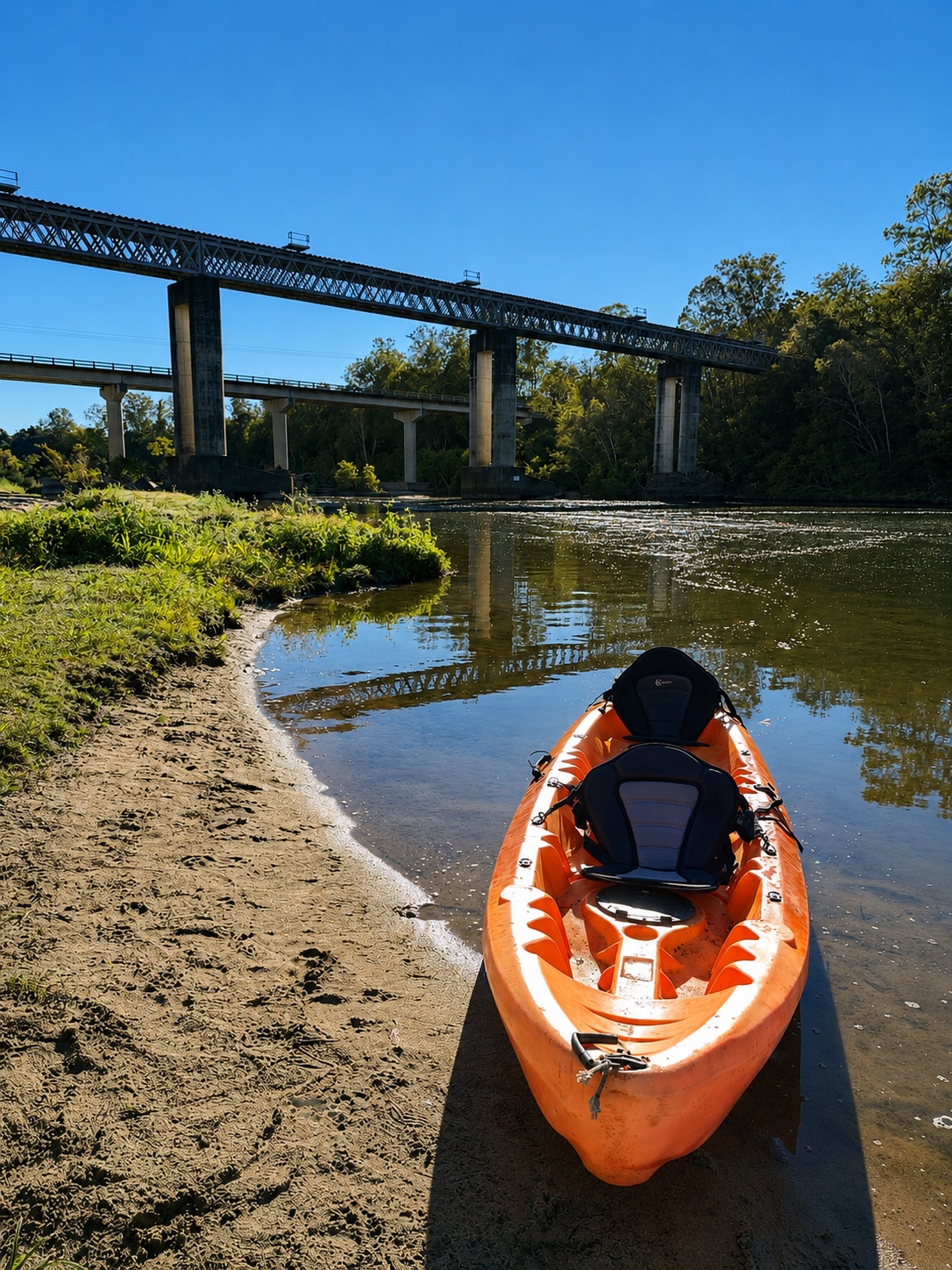 Orange tandem kayak waiting beside the bridge
