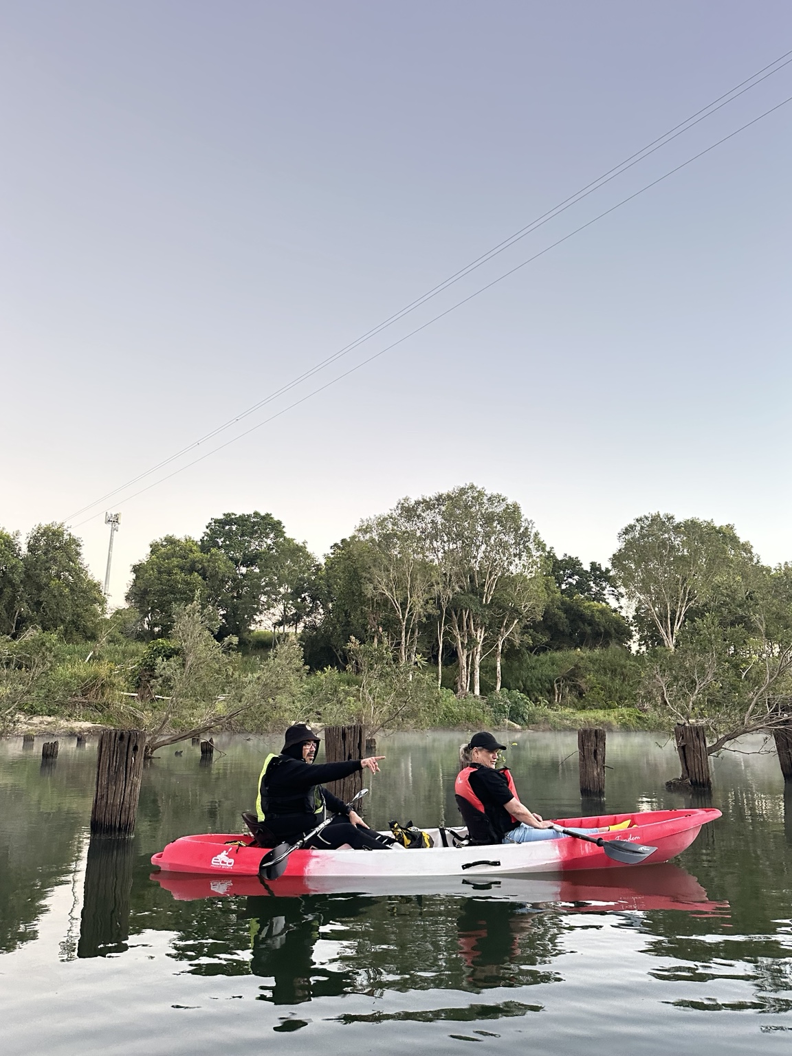 John pointing out wildlife from a tandem kayak